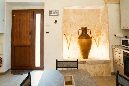 a kitchen with a table and a vase on the wall at My Family Home in Francavilla Fontana
