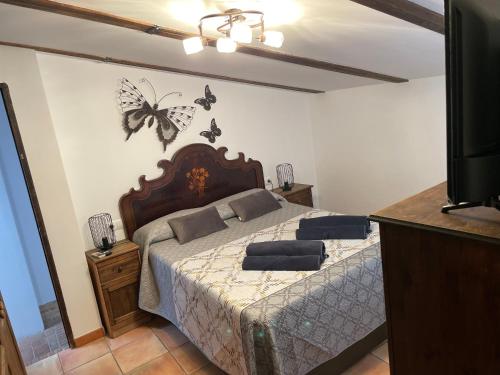 1 dormitorio con 1 cama con mariposas en la pared en Esencia de Arcos, en Arcos de la Frontera