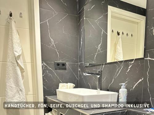 ein Bad mit einem Waschbecken und einem Spiegel in der Unterkunft Suite Lombardi - Terrasse, Babybett, Doppelbett, Waschmaschine, Ruhige Lage in Bieber