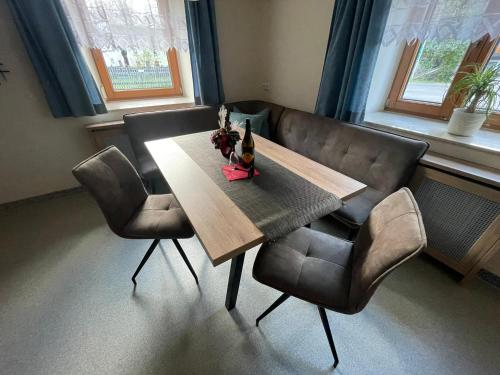 JenigにあるFerienwohnung Jankのダイニングルームテーブル(椅子2脚付)、シャンパン1本