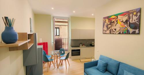 a living room with a blue couch and a kitchen at Barberini Bright Apartment in Rome