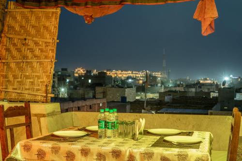 uma mesa com pratos e garrafas de água em cima de uma cidade em Hotel Marina Mahal with Swimming Pool em Jaisalmer
