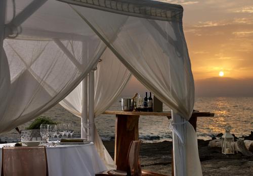 a dinner table in a tent on the beach at sunset at Alas Resort & Spa in Elia Laconias