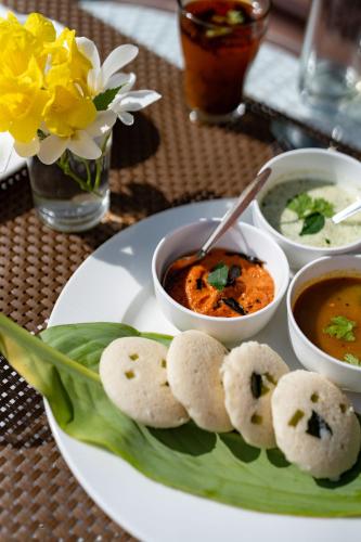 a plate of food on a table with soup andplings at Vesta Avtar Resort Pushkar in Pushkar