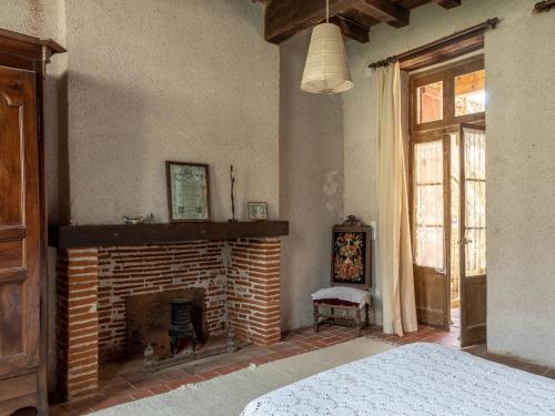 ein Schlafzimmer mit einem gemauerten Kamin und einem Bett in der Unterkunft Gîte d'étape la P'tite Graine in Auvillar