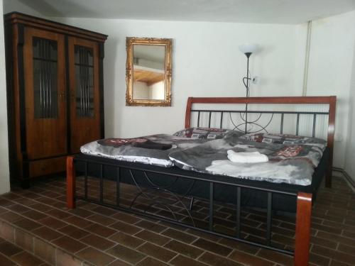 a bed in the corner of a room with a mirror at Penzion U Tomáše in Jindřichŭv Hradec