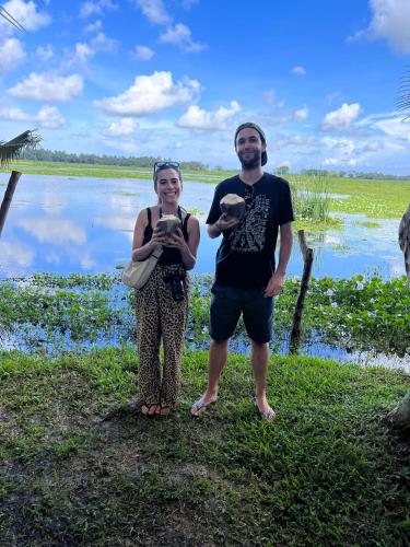 a man and a woman standing next to a body of water at Lake Face Cabana in Tissamaharama