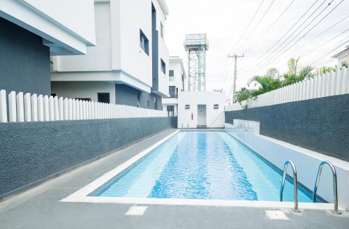 uma piscina em frente a um edifício em Teleworld Apartment em Ikeja