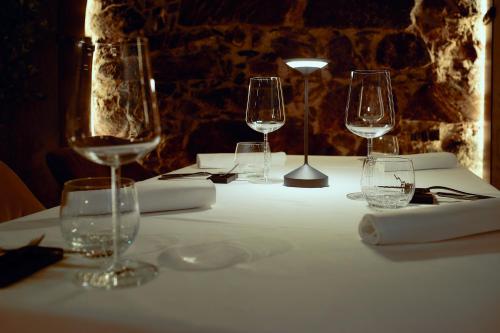 a table with four wine glasses on a white table cloth at The Hotel Ljubljana in Ljubljana