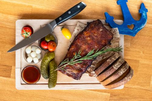 a steak on a cutting board with a knife and vegetables at Hotel U námořníka in Plzeň