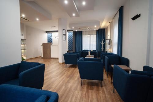 a waiting room with blue chairs and a table at Hotel Palatinus in Sopron