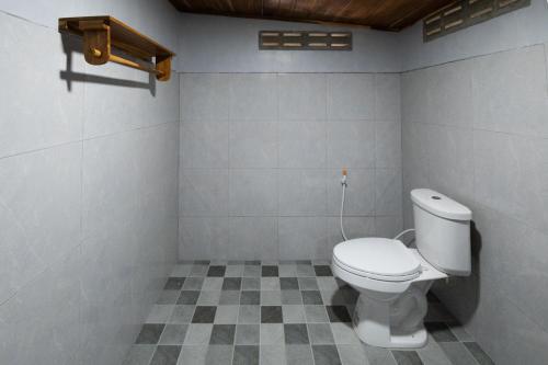 a bathroom with a toilet and a checkered floor at Suk Sabai Homestay in Sukhothai