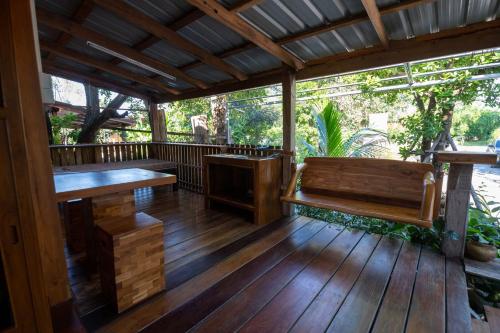 a wooden deck with a bench and a table at Suk Sabai Homestay in Sukhothai