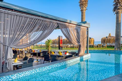 a swimming pool with tables and chairs next to a resort at Megasaray Club Belek in Belek