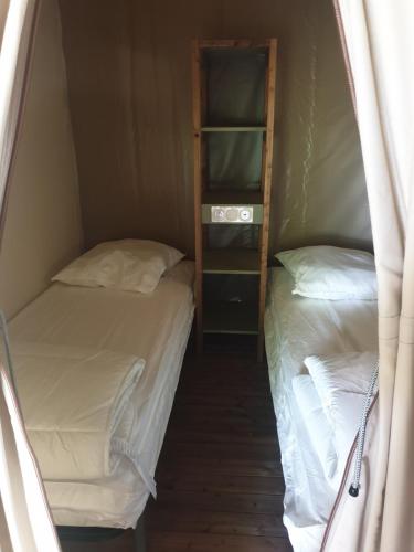 2 Betten in einem kleinen Zimmer nebeneinander in der Unterkunft lodge du camping la Porte St Martin in Saint-Martin-en-Vercors