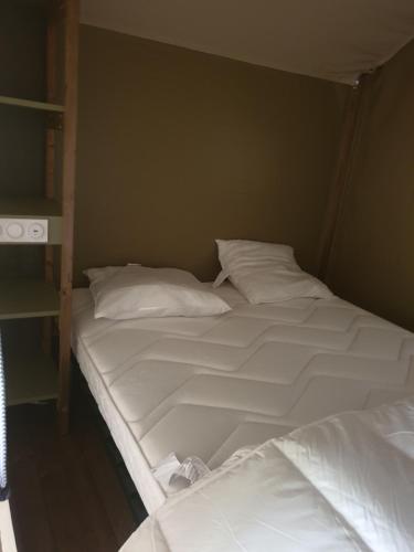 2 Betten mit weißer Bettwäsche und Kissen in einem Zimmer in der Unterkunft lodge du camping la Porte St Martin in Saint-Martin-en-Vercors