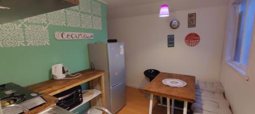 uma pequena cozinha com uma mesa e um frigorífico em Cabaña YaPide em Puerto Varas