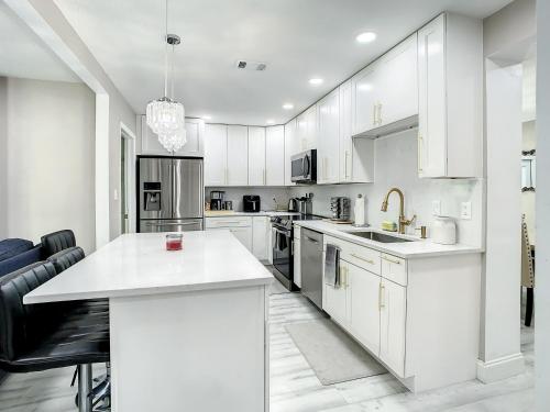 a kitchen with white cabinets and a white counter top at AMI, IMG, Beach, Bikes, Golf, Hottub, Fish, Beach, BBQ, SRQ in Bradenton