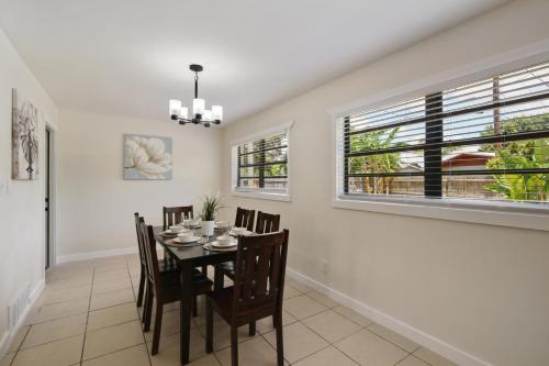 a dining room with a table and chairs and two windows at 3 bedroom House with Renovated kitchen and bath! in Cocoa