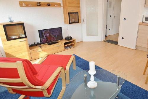 een woonkamer met een tafel en stoelen en een televisie bij Ruth Whg 3 in Grömitz