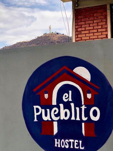 a sign for a hotel on top of a wall at El Pueblito in Cochabamba
