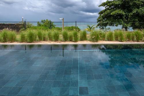 una piscina con suelo de baldosa azul en Prestigious waterfront apartment with huge pool! en Pointe aux Piments