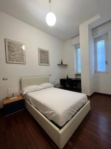 a bedroom with a white bed and a desk at Bocconi Apartment in Milan