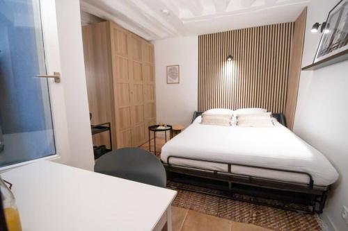 une petite chambre avec deux lits et une chaise dans l'établissement cosy studio#heart of Le Marais, à Paris