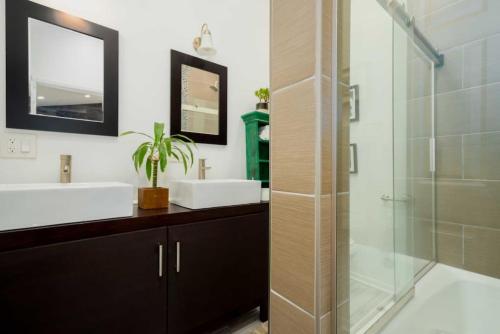 a bathroom with two sinks and a glass shower at Hillside Artist Retreat 3BR - Hills of Eagle Rock in Los Angeles