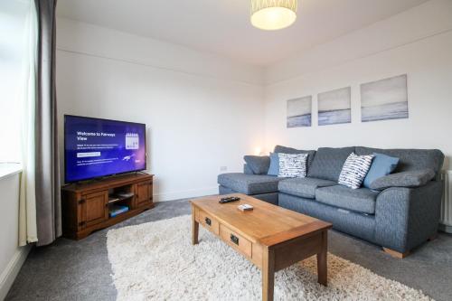 a living room with a couch and a tv at Fairways View - Spacious Apartment - Sleeps 6 - Lovely Views - by Rework Accommodation in Hoylake