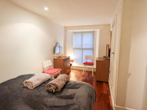 a bedroom with a bed and a dresser and a window at Wood Cottage in Kendal