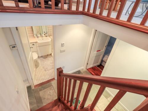 ケンダルにあるWood Cottageの洗面台とバスルームが備わり、階段を見渡せます。