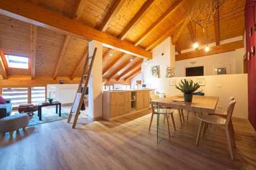 a kitchen and dining room with a wooden ceiling at LE MUSE Comano Terme Holiday 2, primo piano in Comano Terme