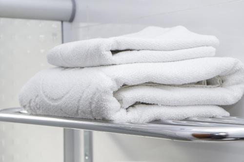 a stack of towels sitting on a towel rack at JP Palace Hotel in Franca