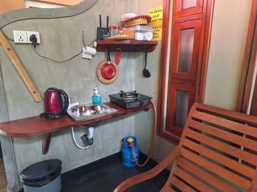 a small kitchen with a sink and a stove at Thara Cabana in Bentota