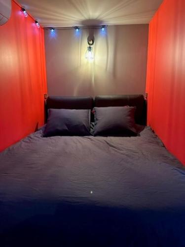 een slaapkamer met een bed met rode muren en verlichting bij Love Room Cocooning & Spa in Épinal