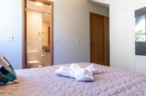 um quarto com uma cama com toalhas em Bangalô luxo à beira MAR em Porto de Galinhas (Cupe) em Recife
