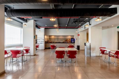 卡门城City Express Junior by Marriott Ciudad del Carmen的有桌子和红色椅子的餐厅