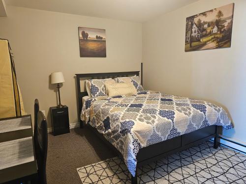 a bedroom with a bed with a blue and white comforter at Quad-Ks Cozy & Private Guest Suite in Halifax