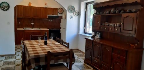 cocina con mesa, sillas y fregadero en Apartments Belak, en Brodarica