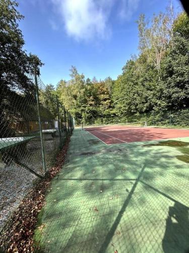 a tennis court with a net on a tennis court at Chaleureux chalet à Durbuy in Durbuy