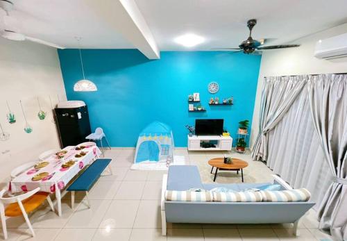 a living room with two beds and a blue wall at THE BLUE HOUSE in Kamunting