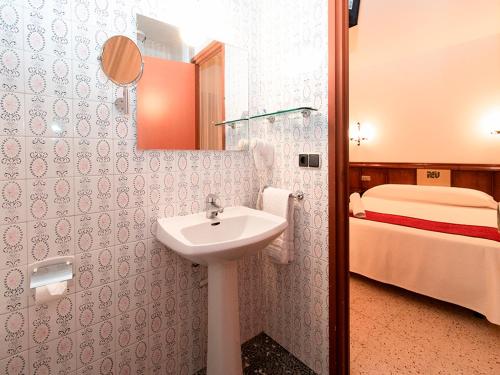 a bathroom with a sink and a bed at Hotel Pere D'Urg 3000 in Encamp