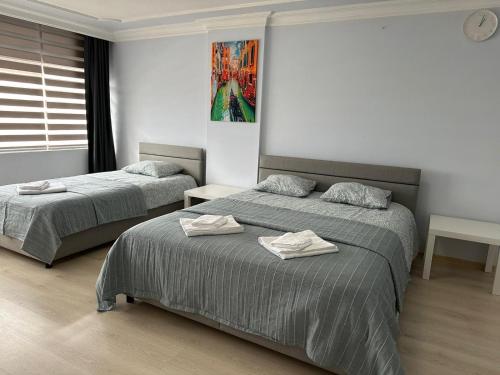 een slaapkamer met 2 bedden en handdoeken bij Şehir Merkezinde Daire in Antalya