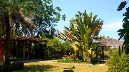a garden with palm trees and a pavilion at Ban Bang Home Resort in Haad Chao Samran