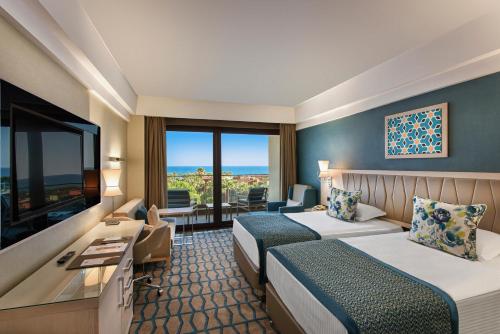 a hotel room with two beds and a flat screen tv at Megasaray Club Belek in Belek