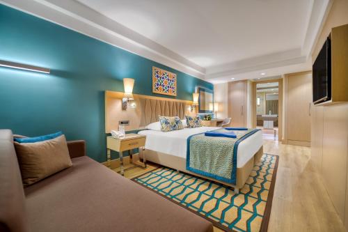 a hotel room with a bed and a couch at Megasaray Club Belek in Belek