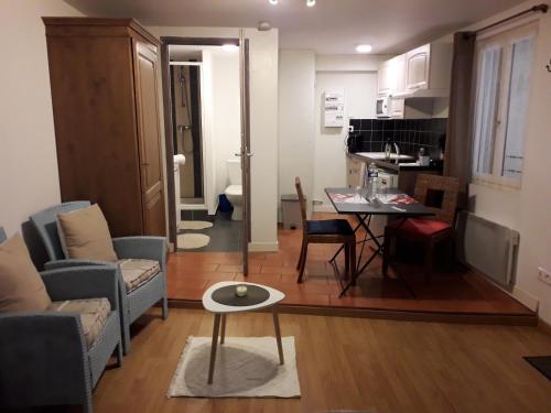 a living room and kitchen with a table and chairs at Appart-Hôtel Résidence Maloc in Malaucène