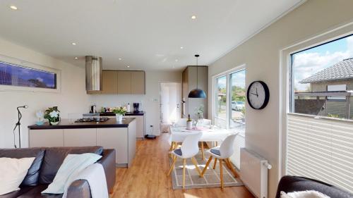 eine Küche und ein Wohnzimmer mit einem Sofa und einem Tisch in der Unterkunft Haus MeerAuszeit - Erholung an der Nordsee in Schweiburg