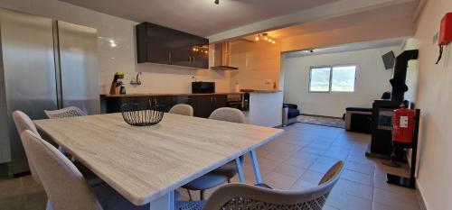 a kitchen with a wooden table and chairs in a room at Casa Vista do Monte in Povoação